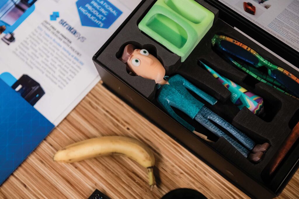 a toy figurine in a box with a banana and a calculator