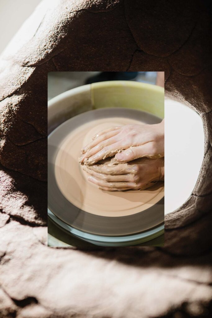 a person's hands on a pottery wheel