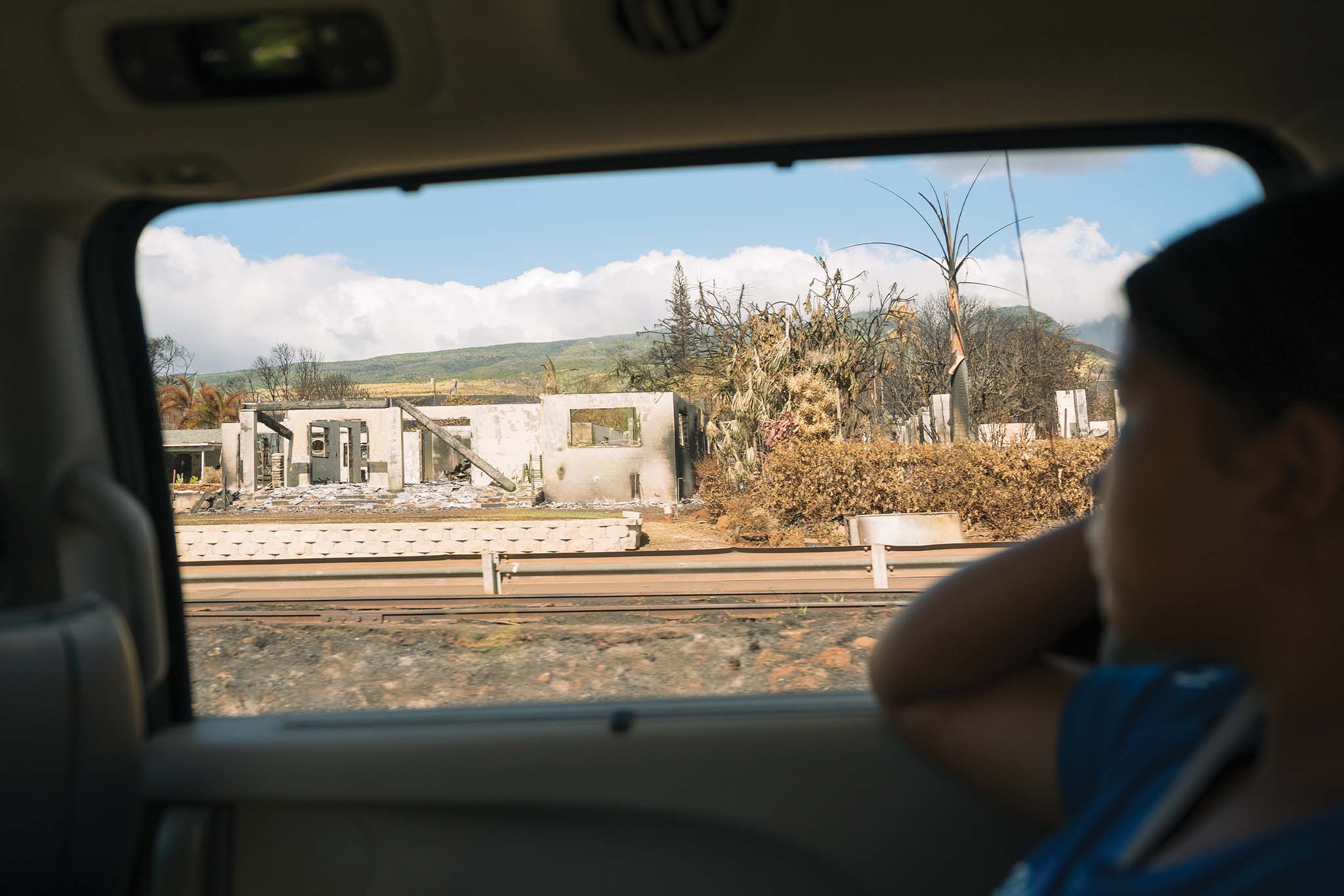 person in car looking outside, driving by maui